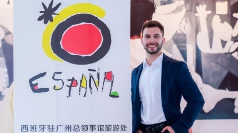 L'exalumne Samuel Rodriguez posa davant del rollup amb el logo de Turismo de España 