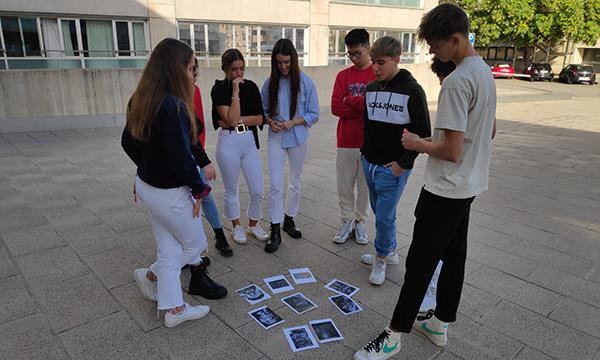 Estudiants en grup miren al terra unes fotografies