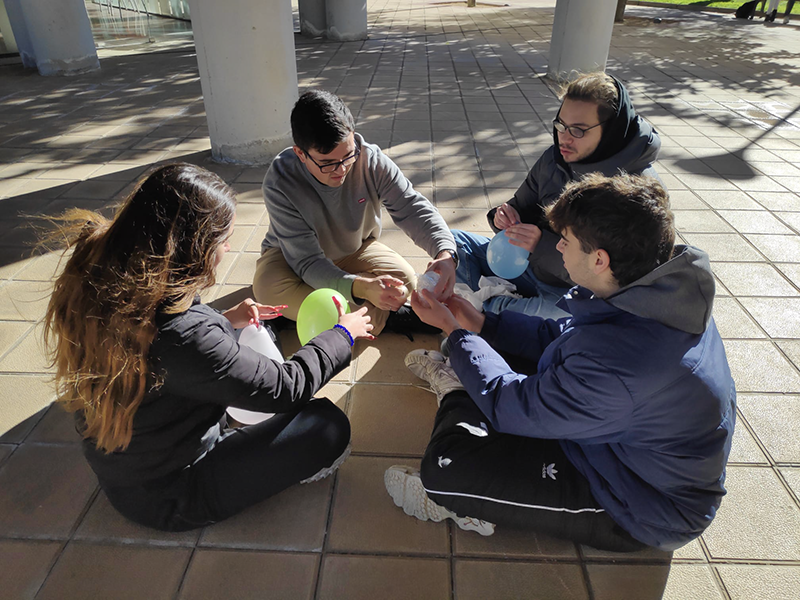 Estudiantes creando un sistema para que no rompa el huevo de chocolate durante la caída