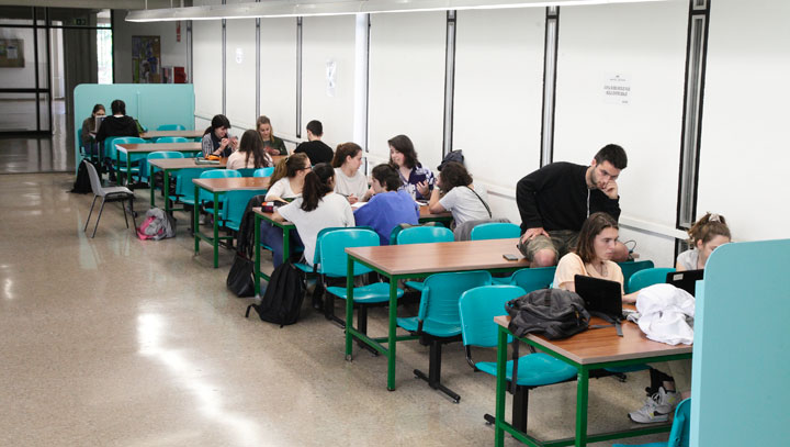 Alumnat estudiant a les taules de l'interior de la Facultat