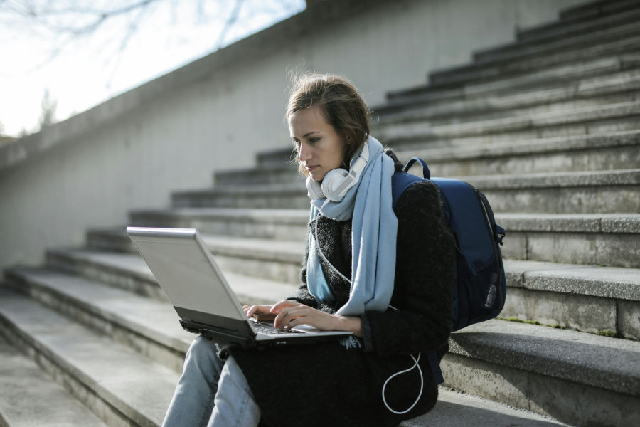 Una noia amb un portàtil a la universitat