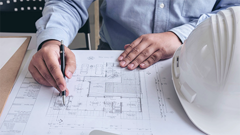 Un professional revisant un plànol d'un edifici