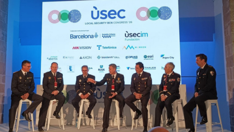 Un grup de ponents del congrés fa un debat amb la pantalla de patrocinadors al fons