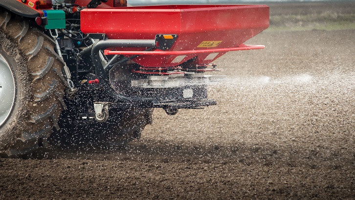 Tractor i distribuïdor de fertilitzant al camp