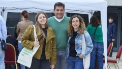 Pare, mare i filla posen somrient davant una carpa en el Dia de les Famílies