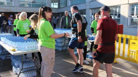 Voluntària repartint aigua als participants durant la Cursa 2022