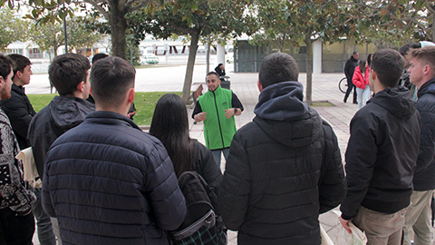 Estudiant de suport a la promoció dels estudis atenent a un grup de visitants