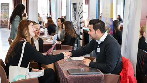 Encaixada de mans entre estudiants i representant del sector turístic i hoteler