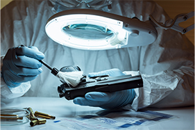 Investigador inspecciona una arma de foc al laboratori