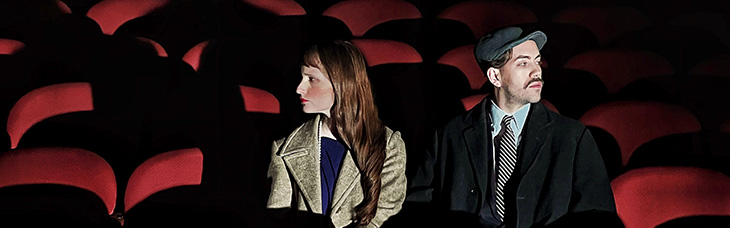 una dona i un homes aasegut en les butaques d'un cinema