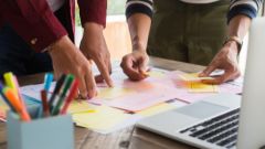 Dues persones treballen amb post-its