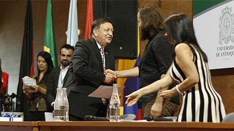 El presidente de FELAFACS, Álvaro Rojas, entrega el premio a Claudio Maldonado. FOTO: CIESPAL