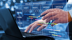 Una pantalla de project management i una mà assenyalant amb el bolígraf