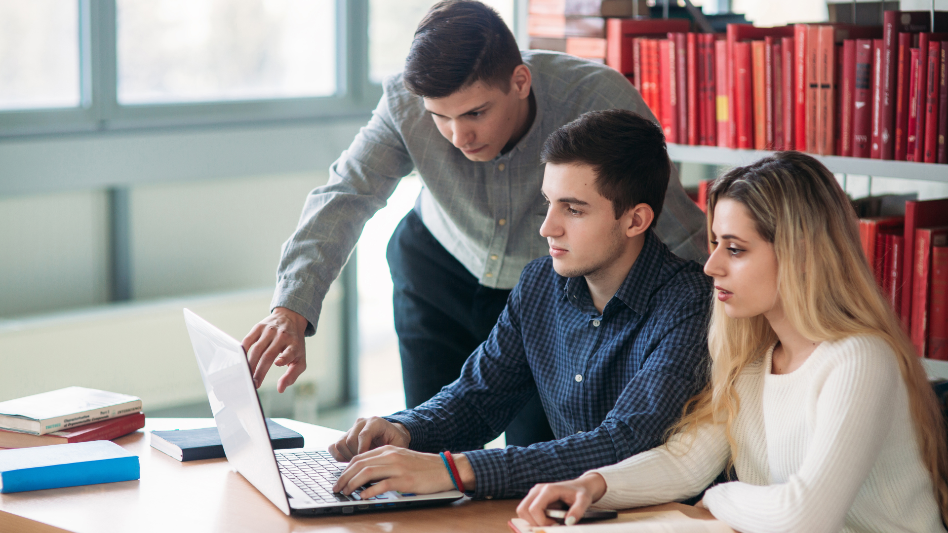  3 estudiantes consultando información al ordenador