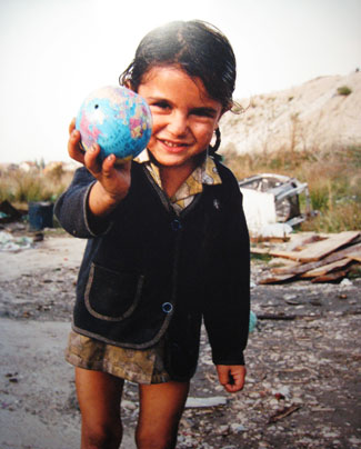Nena subjectant un petit globus terráqueo en les seves mans.