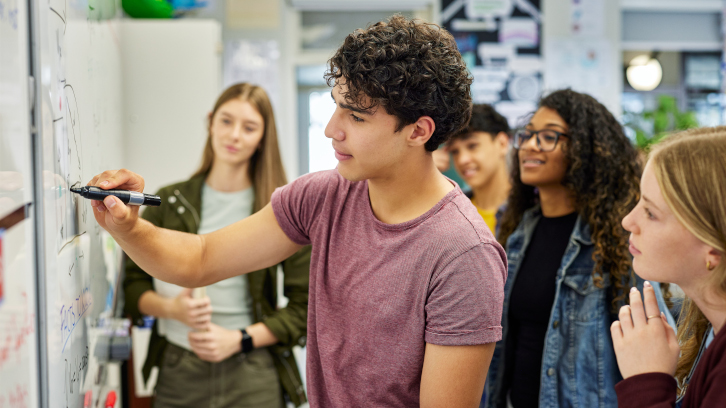 Alumnes resolent problemes en una pissarra