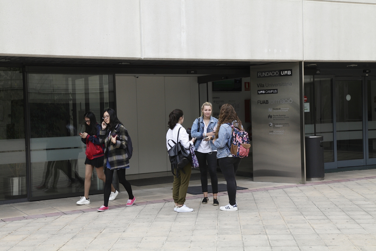 Noies xerrant a la entrada de l'Escola Universitària de Turisme i Direcció Hotelera de la UAB