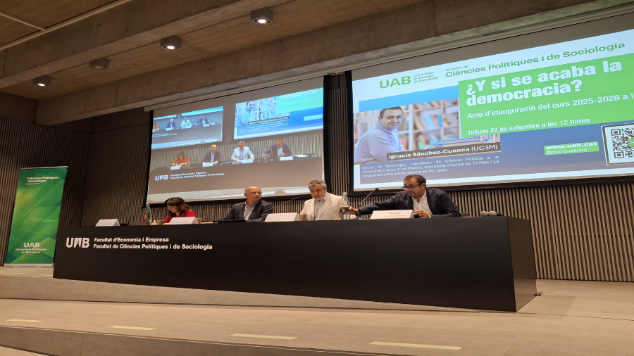 Es veu la sala d'actes amb una taula on seuen els conferenciants