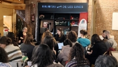 Un grup d'estudiants escolta una ponent a un espai anomenat Biblioteca de les Eines