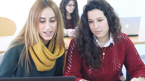 Noies estudiant a l'aula