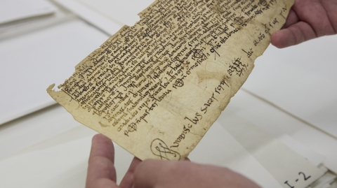 Dues mans sostenen un document antic