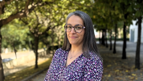 Anahí Casadesús, directora, dona amb cabell llarg llis, ulleres i vestit morat estampat