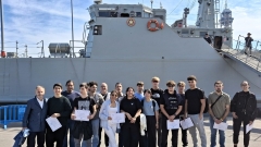 Un grup d'alumnes posa davant d'un vaixell caçamines