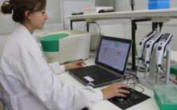 Tècnica de laboratori treballant amb un ordinador portàtil