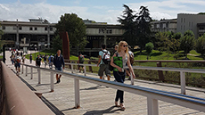 Noia estudiant caminant pel pont de la Plaça Cívica