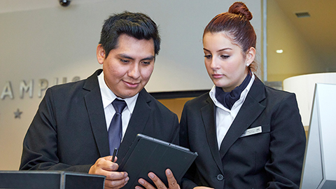 Estudiants en pràctiques a l'Hotel consultant la tablet