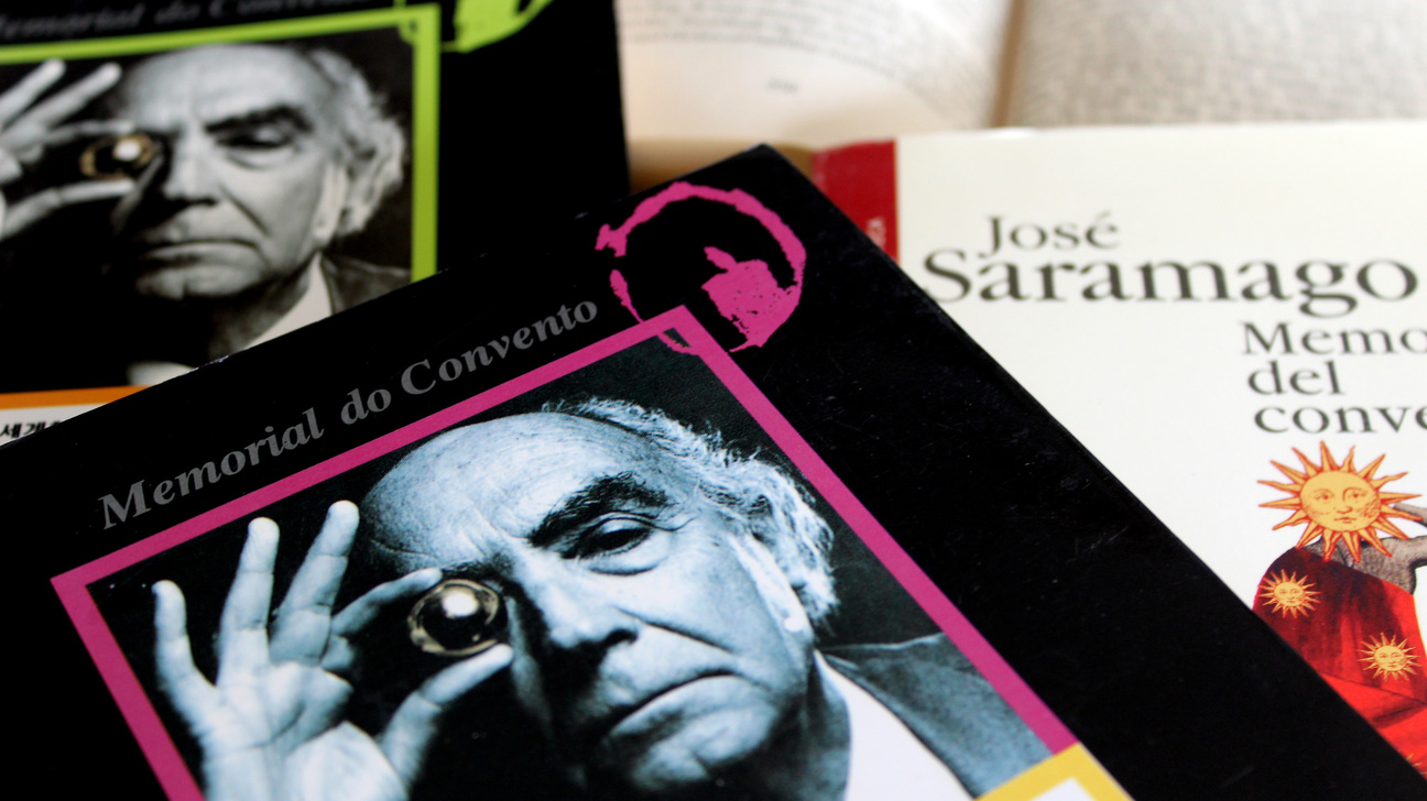Fotografia de diversos llibres de José Saramago, amb un exemplar de Memorial del convent en primer pla i altres llibres i un retrat en blanc i negre de l’escriptor al fons.