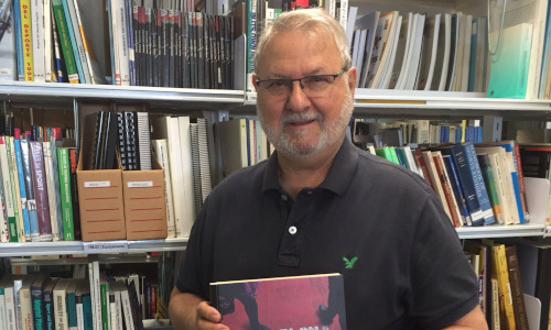 Fotografia de Miquel de Moragas amb una llibreria de biblioteca al fons