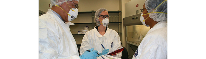 inspectors fent preguntes a la tècnica de laboratori