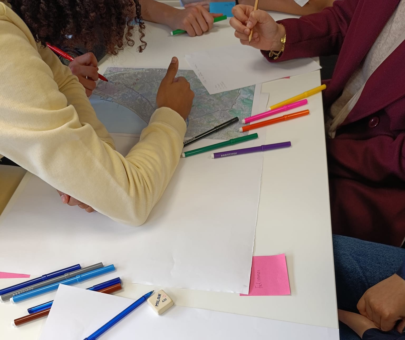 Alumne dibuixant en una làmina, només es veu la làmina i la mà.