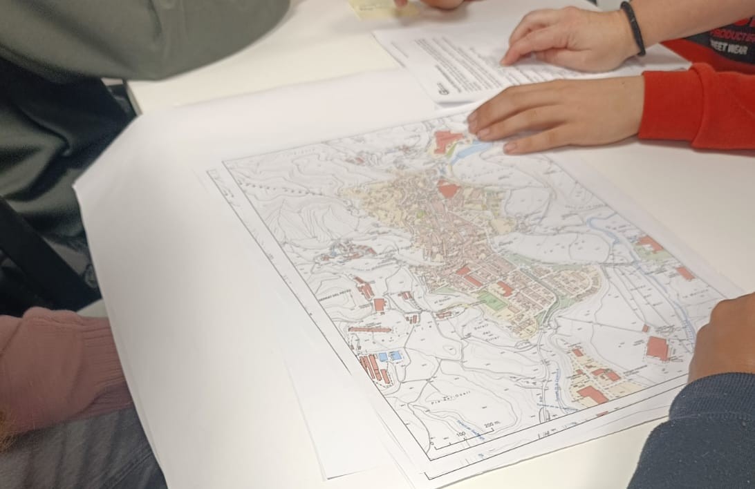 Alumnes al voltant d'un mapa