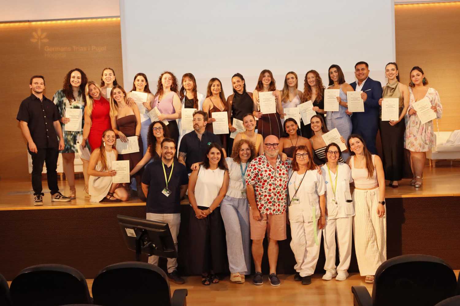 Grup de gent premiada a la cloenda del màster dalt de l'escenari