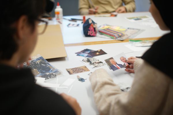 Dos estudiants estan asseguts en una taula elaborant un fanzín