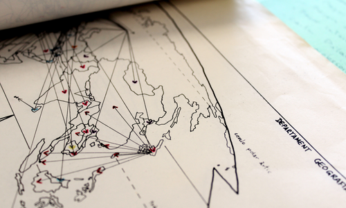 Map with coloured lines and arrows connecting various geographical points, drawn on paper with visible handwritten annotations by Enric Lluch.
