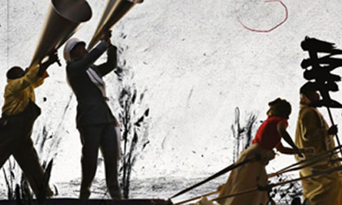 La imagen muestra a un grupo de personas de pie sobre un escenario. En primer plano, dos de ellas sostienen grandes instrumentos de viento, similares a trompas, que levantan hacia arriba.