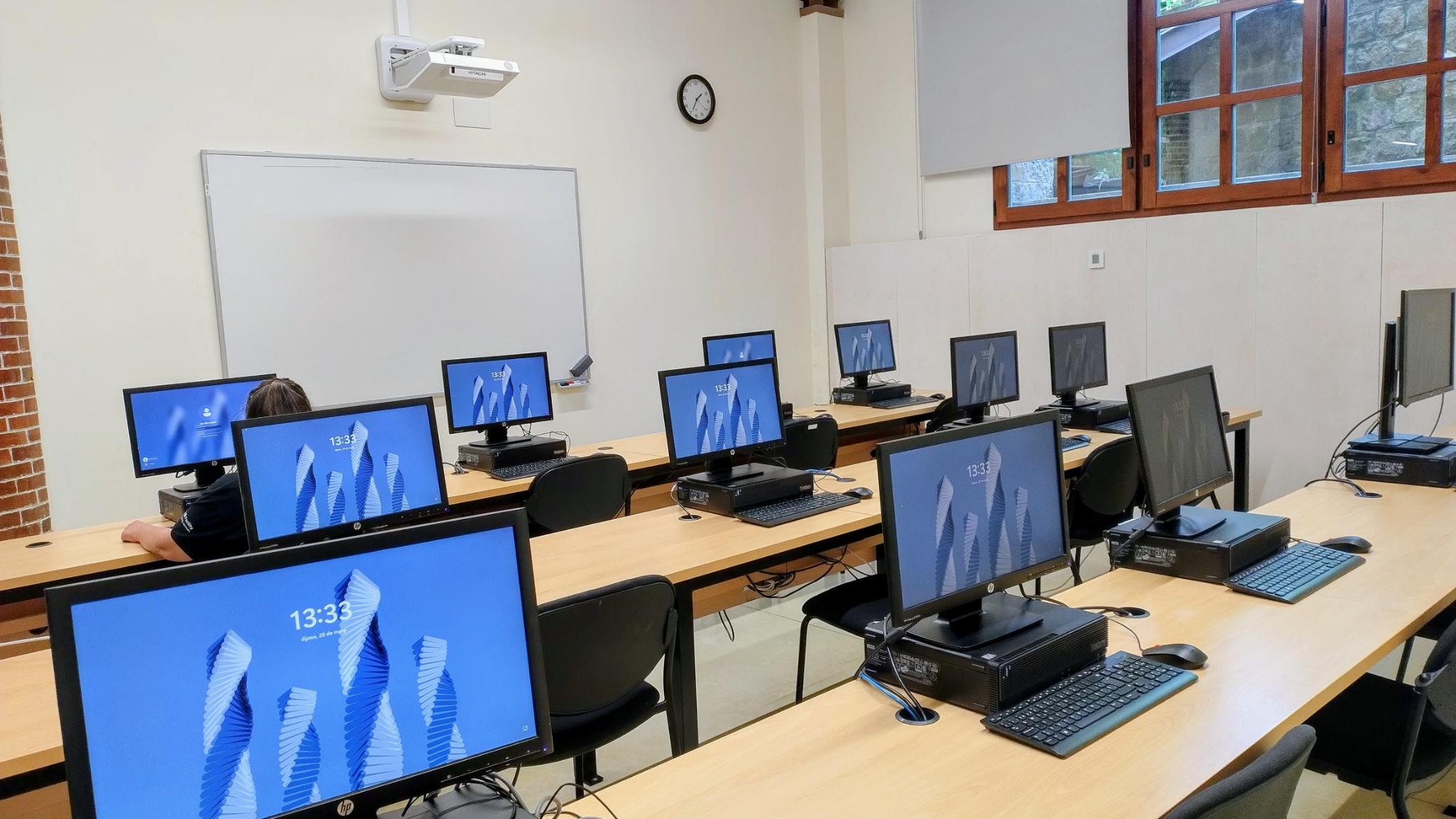 Un aula de informática con alumnos delante de los ordenadores