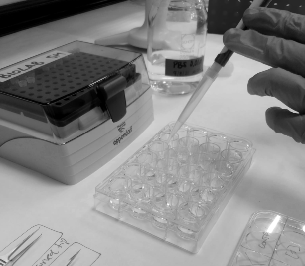Imagen del laboratorio donde se ven unas manos con guantes que sostienen una pipeta